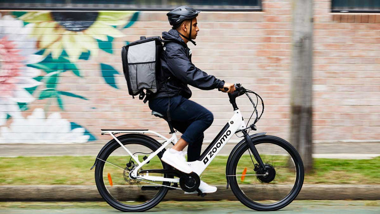 Delivery courier test riding electric bike.